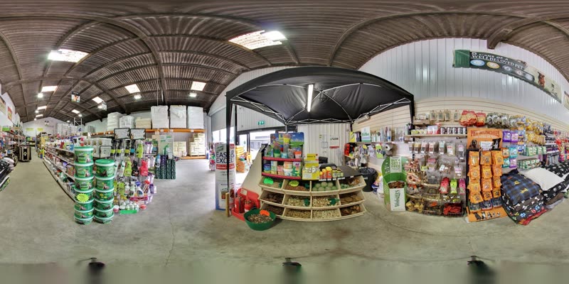 Inside the shop: aisles of feed sacks, bedding and hay under the barn roof